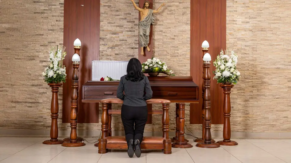 Sala de velación de Durán con crucifijo y arreglos florales