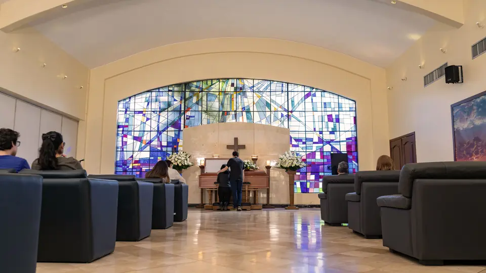 Sala de velación de La Aurora con vitral, sillones y altar